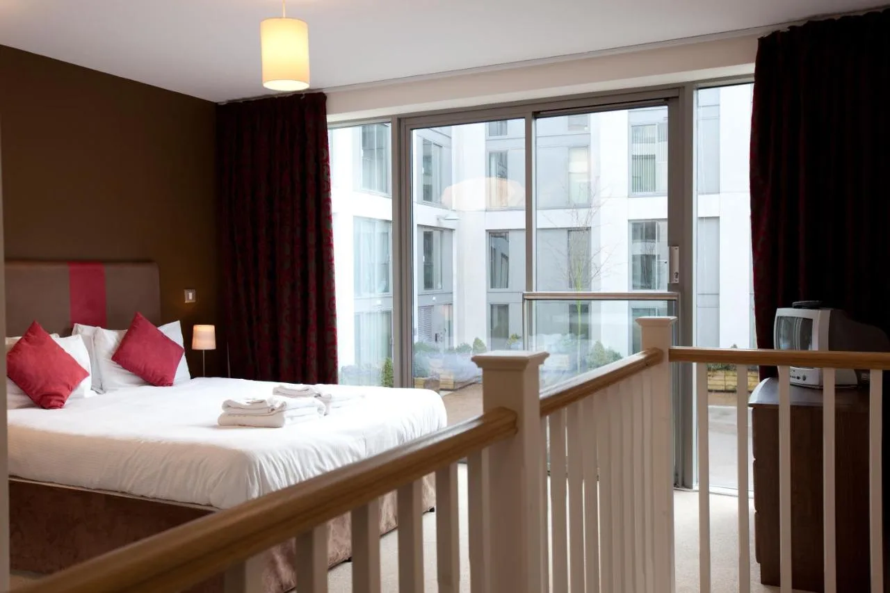 a bedroom with a bed and a large window at The Spires Serviced Apartments Birmingham in Birmingham