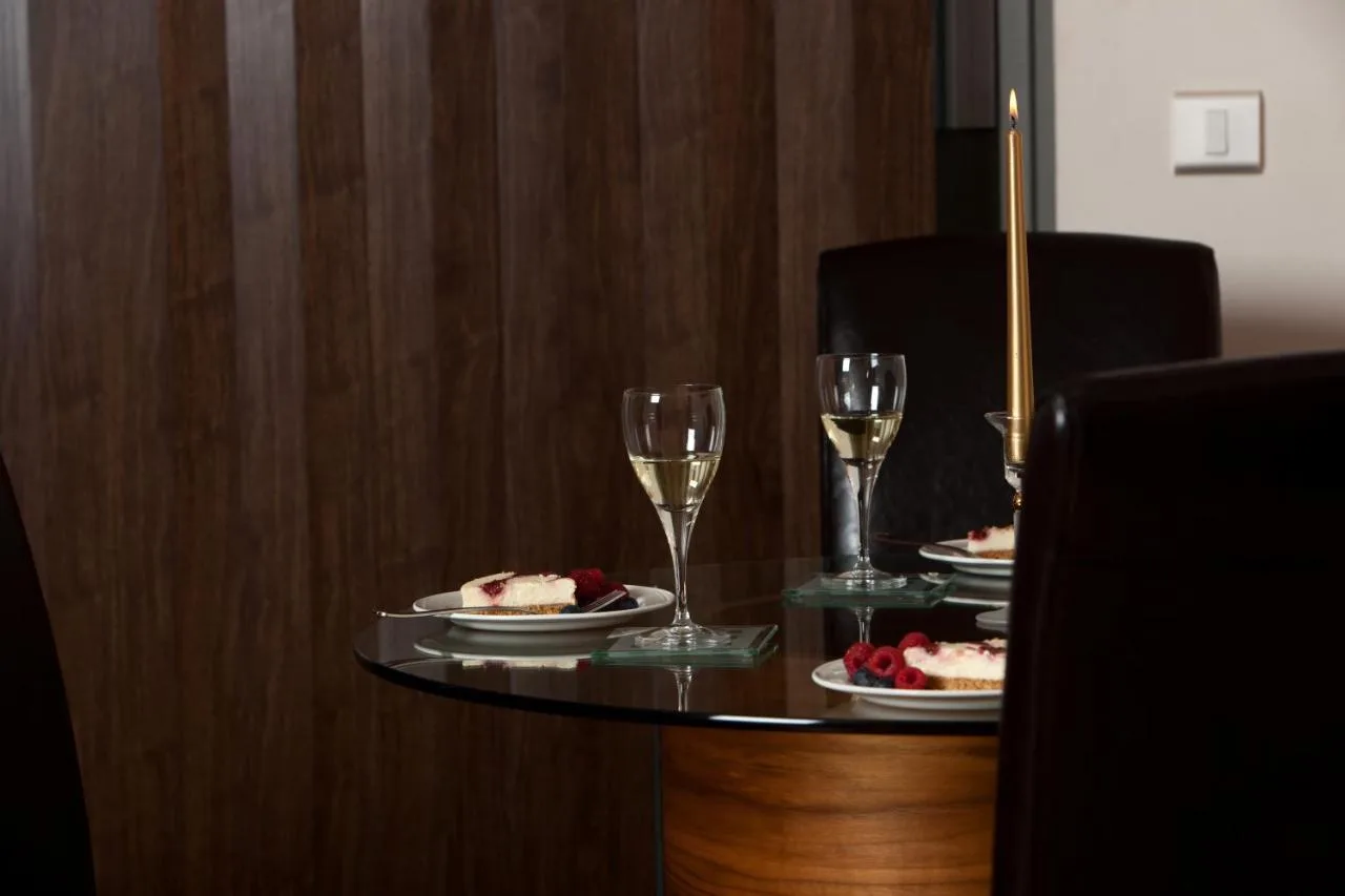 a table with plates of food and glasses of wine at The Spires Serviced Apartments Birmingham in Birmingham